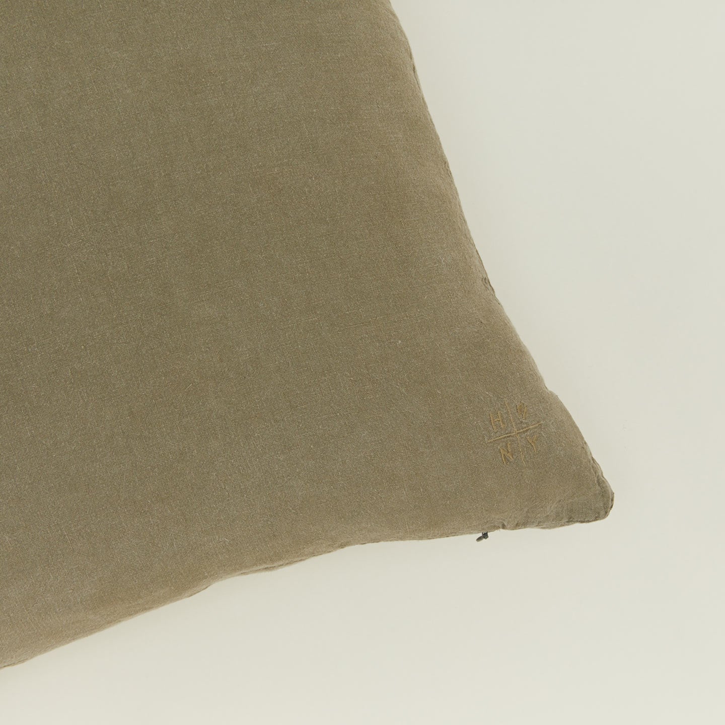 Close up view of simple linen pillow in olive