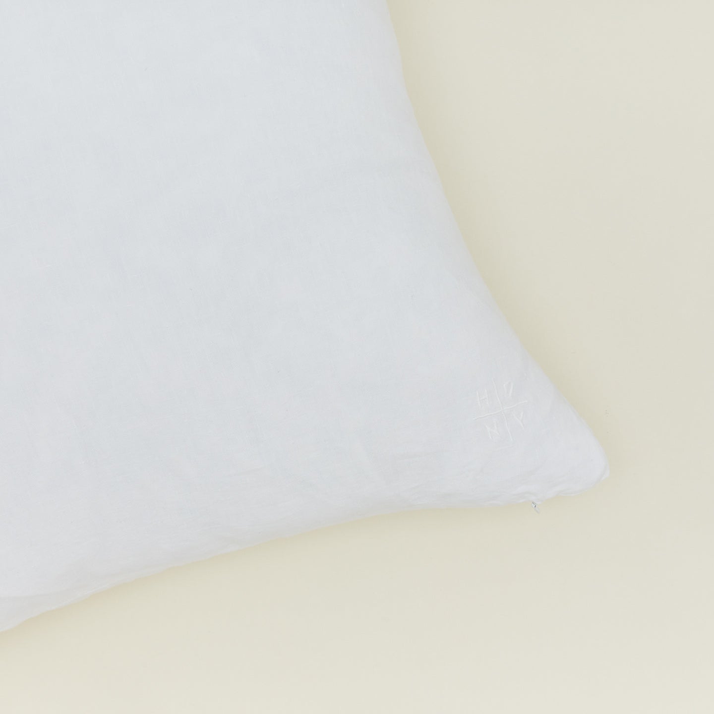 Close up view of simple linen pillow in white