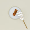 Simple metal fish spatula in brass with plate and fish