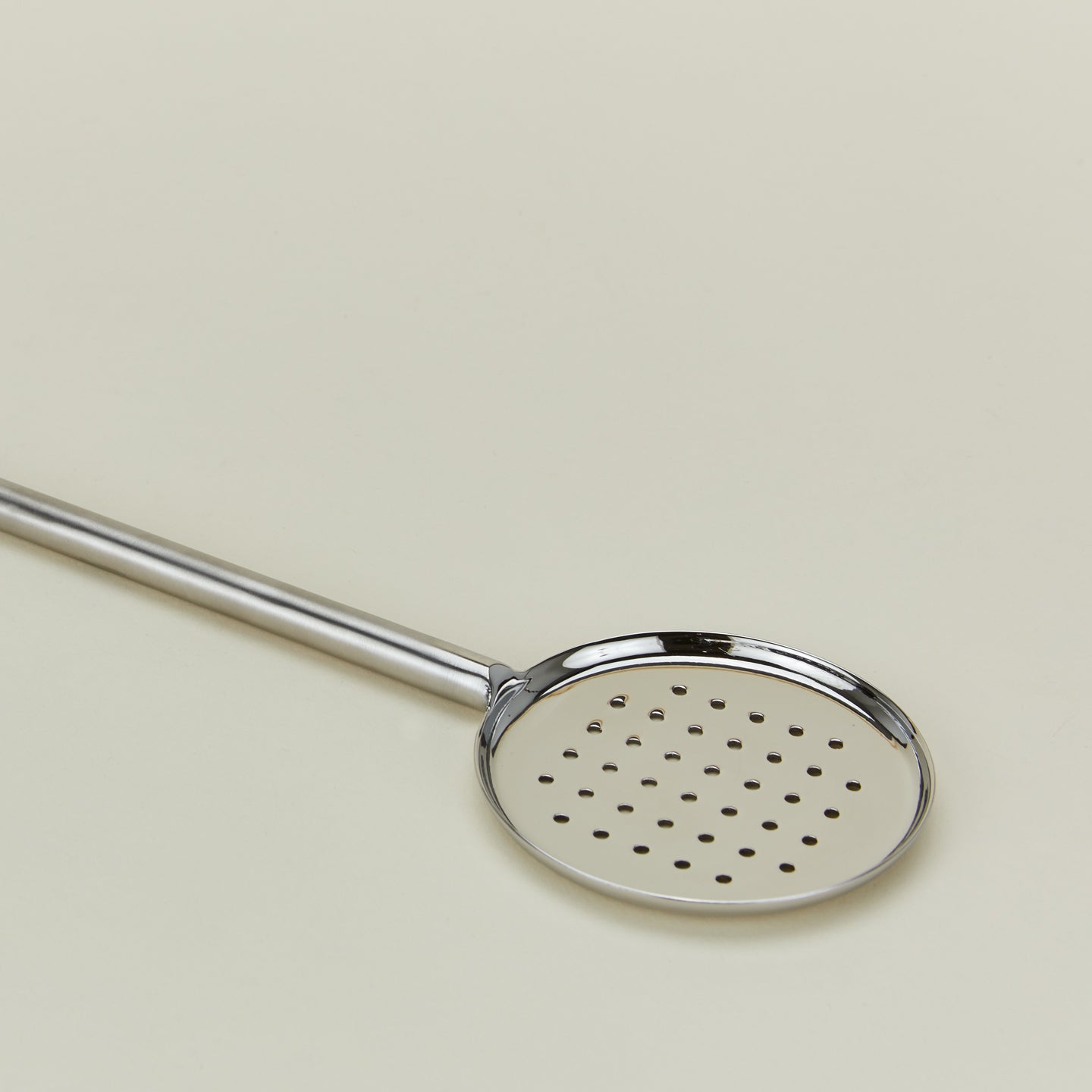 Close up view of Simple metal flat slotted spoon in silver