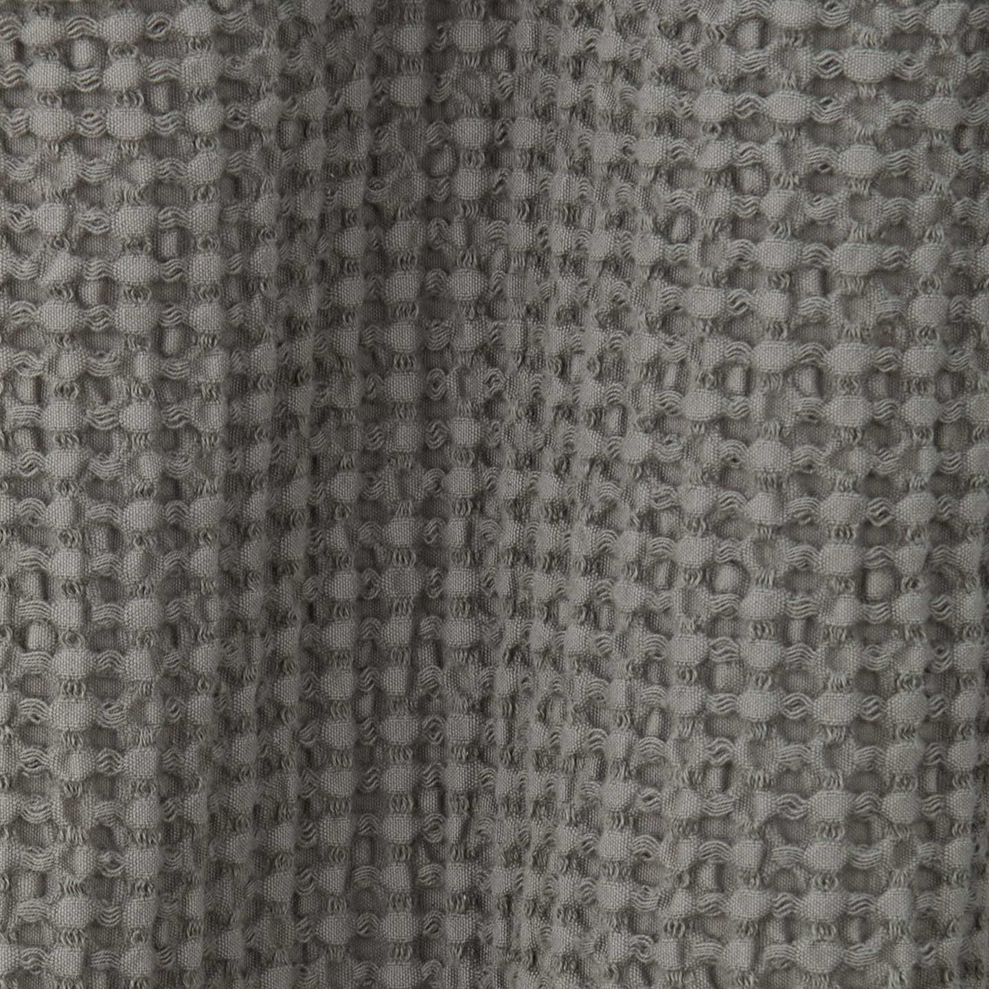 Close up view of simple waffle shower curtain in dark grey