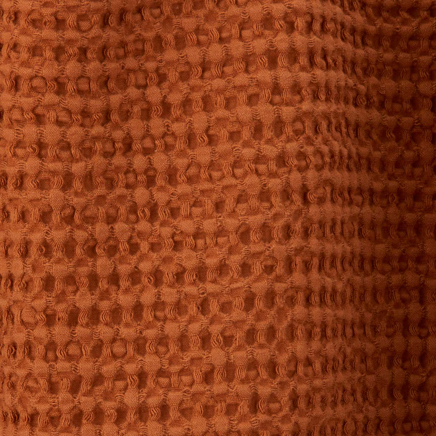 Close up view of simple waffle shower curtain in terracotta
