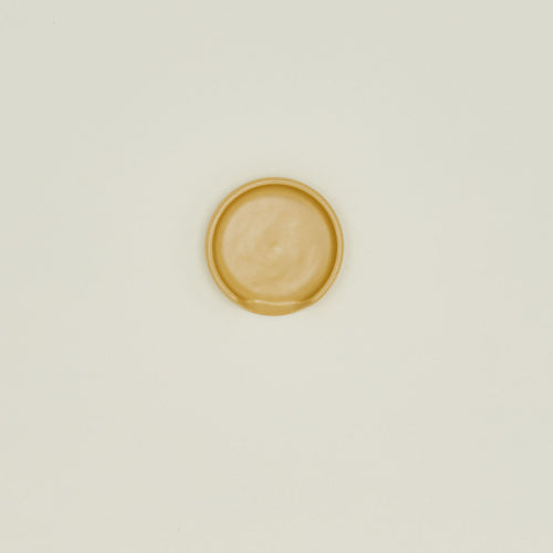 An overhead of a marigold stoneware spoon rest.