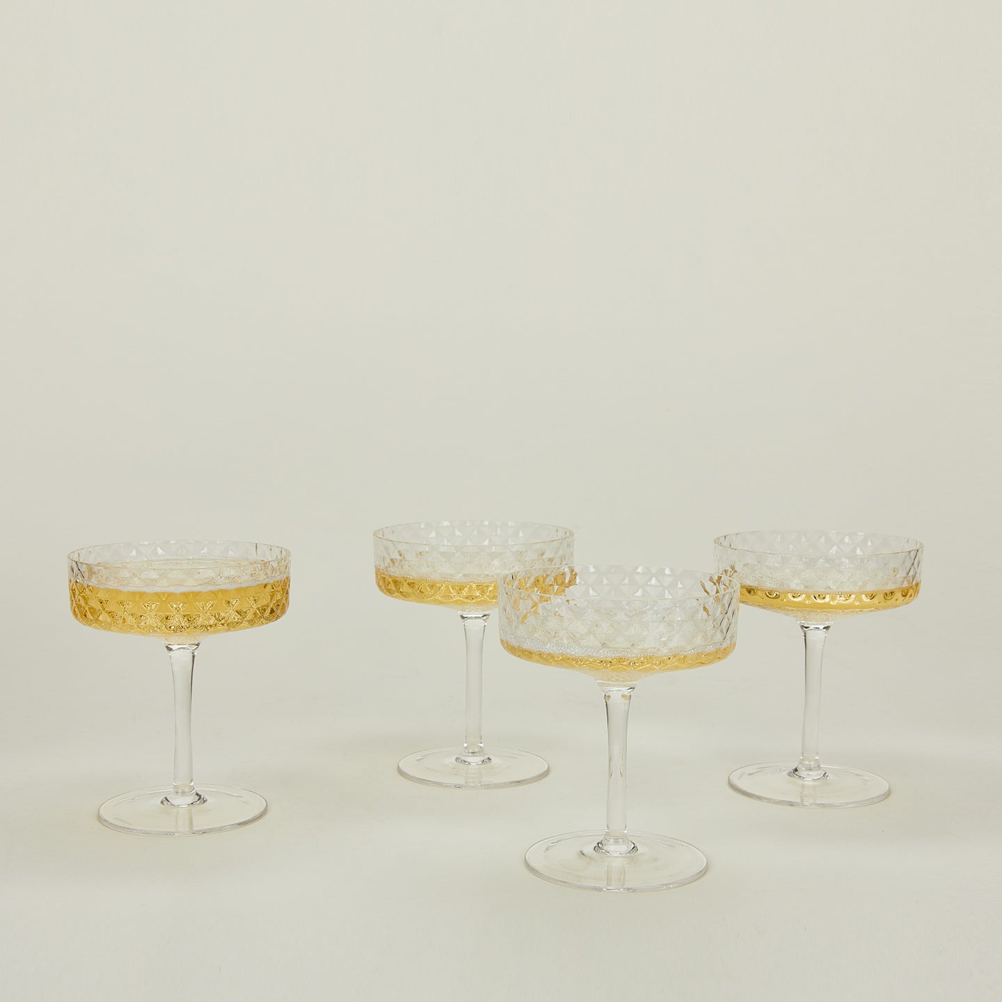 Four Veneziano coupe glasses with champagne.