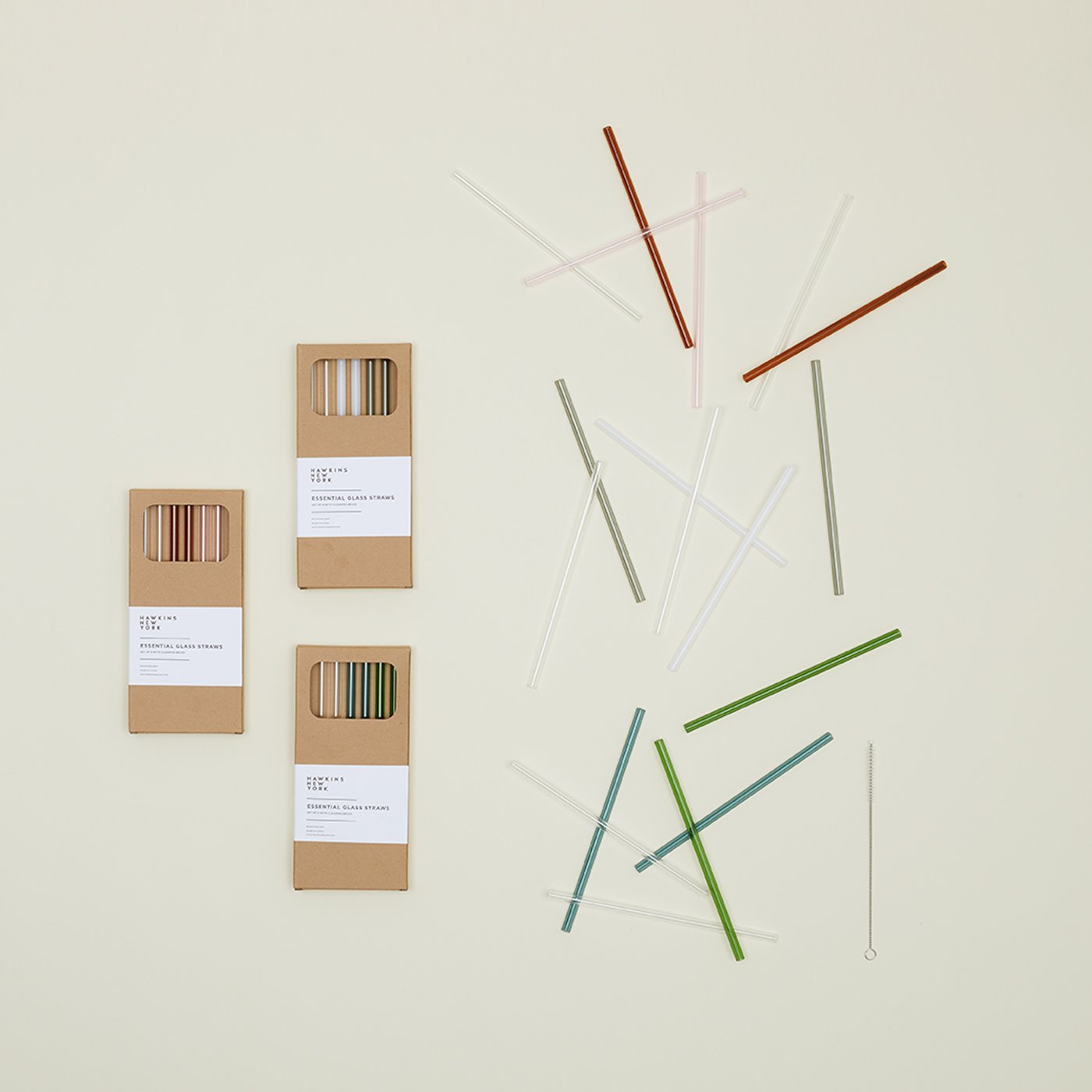 Group of Essential Glass Straw sets in gift boxes, with straws scattered nearby.