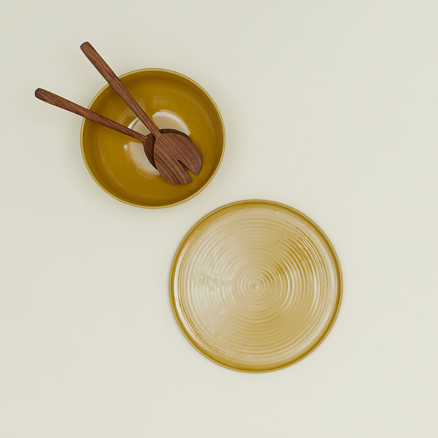 Essential Serving Bowl and Serving Platter in Mustard, with wood serving utensils.